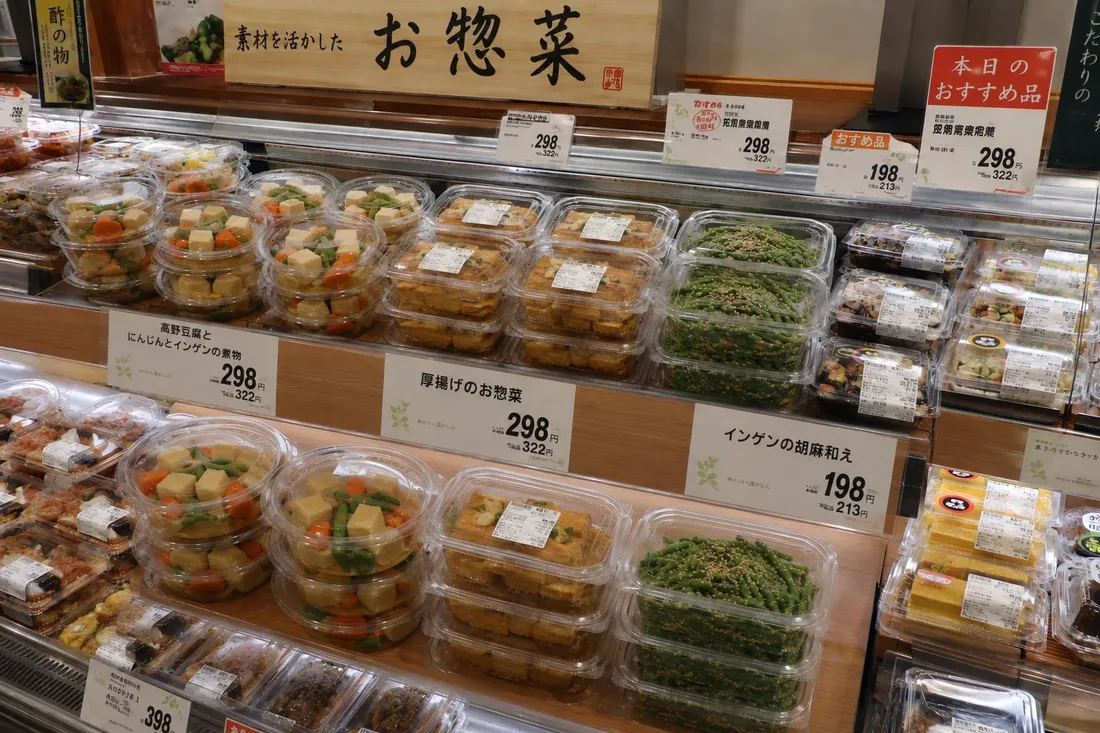 スーパーのお惣菜コーナー。高野豆腐の煮物や厚揚げ、インゲンの胡麻和えなどのパックが並んでいる（イメージ）
